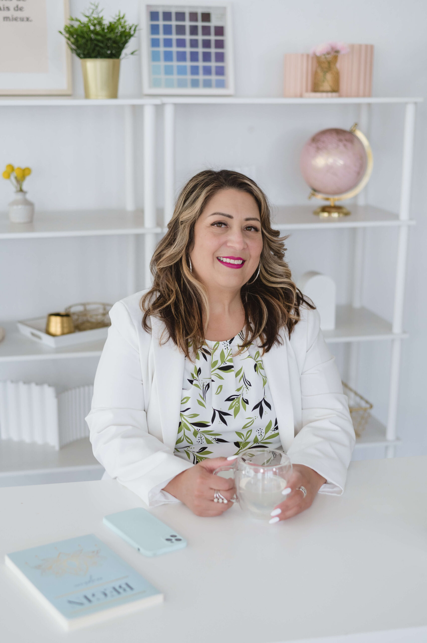 certified RTT Hypnotherapist Annabelle Lindo sitting at her desk with a cup